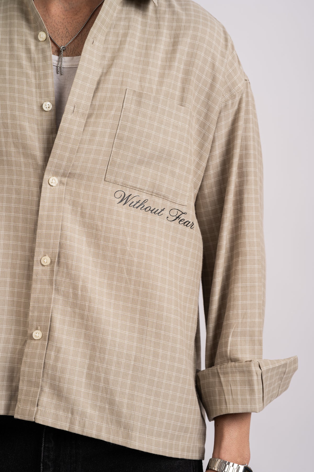 Nomad Check Boxy Shirt- Beige: a relaxed-fit beige button-down with a white windowpane check and the words Without Fear embroidered in cursive on the chest pocket.